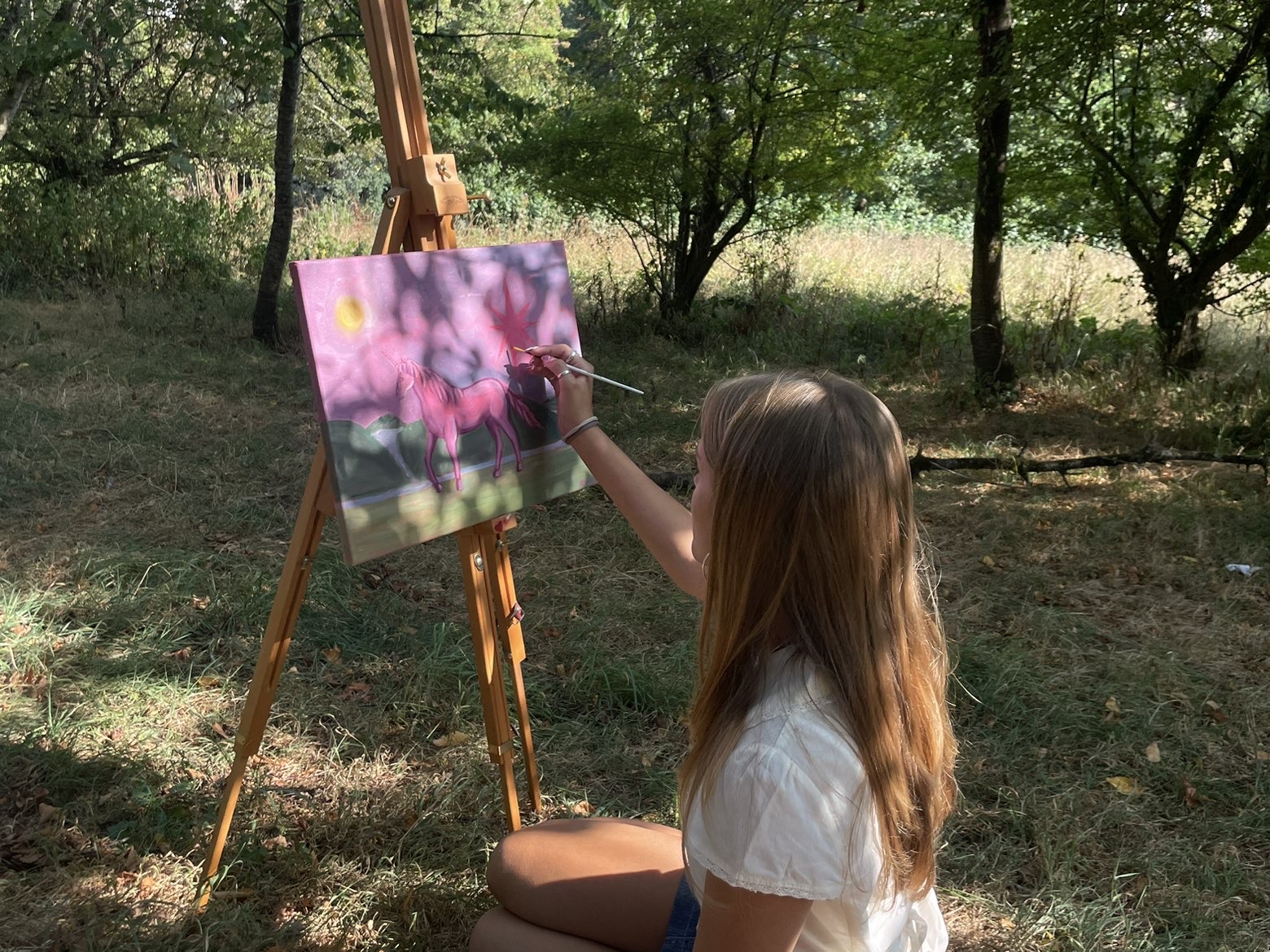 Heidi painting outdoors beside an easel