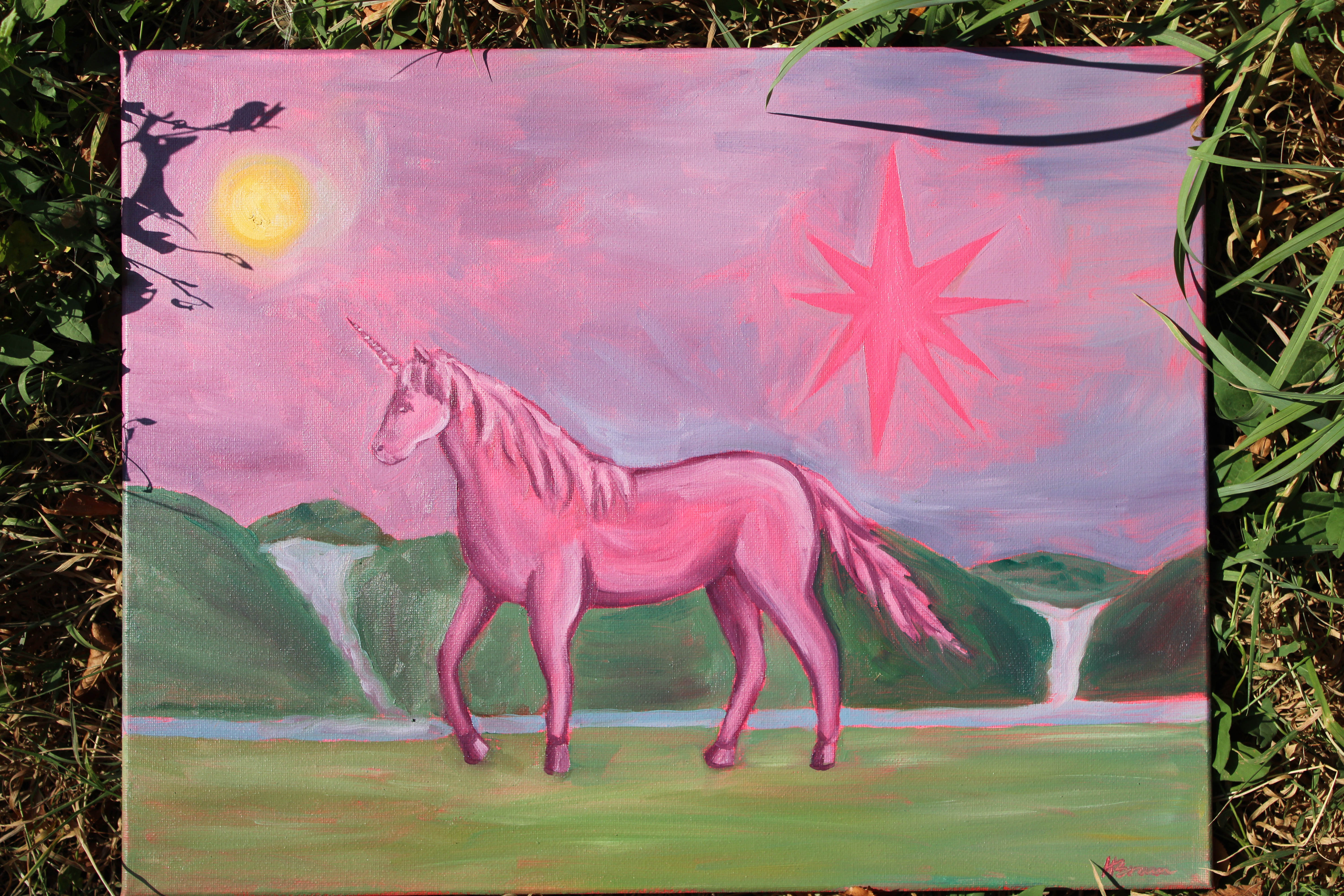 Pink unicorn painting in a green landscape